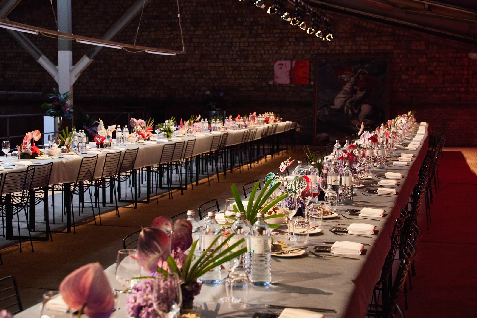 Festlich gedecktes Long-Table-Dinner in der Backsteinhalle des Komplex Berlin