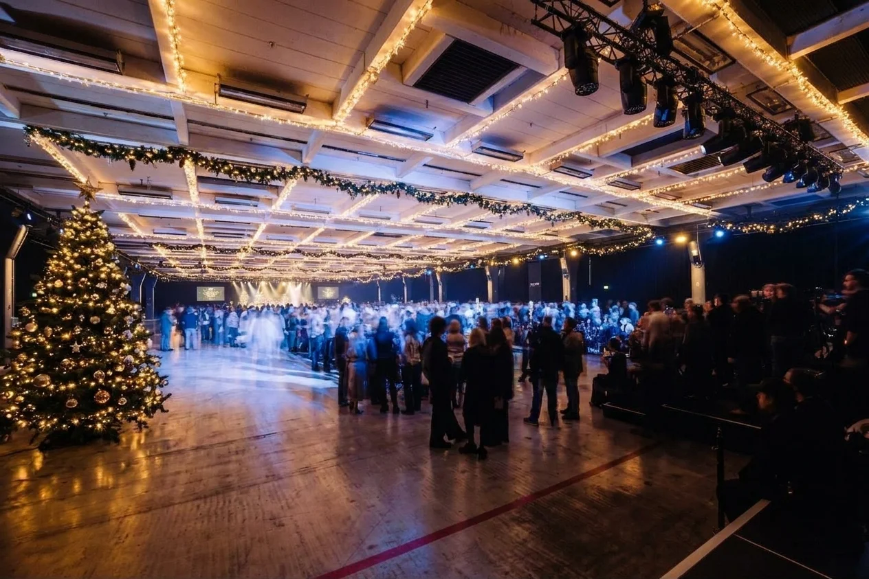 Weihnachtsfeier in der NLND-Halle A2: Gäste unter Lichterketten-Decke mit großem Weihnachtsbaum
